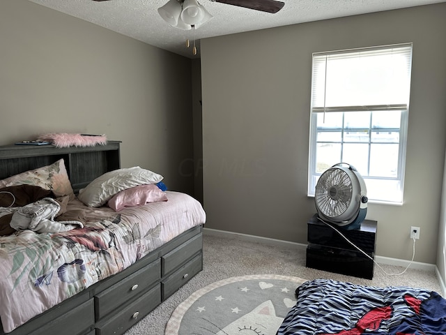 bedroom featuring light carpet, a textured ceiling, and ceiling fan