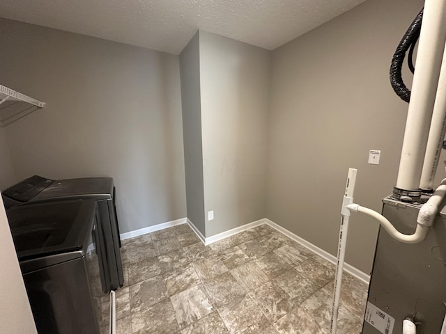 washroom with independent washer and dryer and a textured ceiling