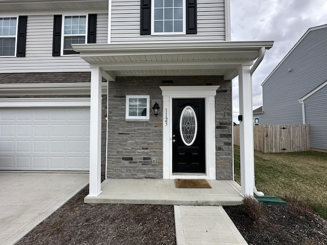 view of exterior entry featuring a yard and a garage