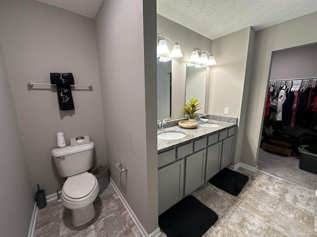 bathroom with vanity, a textured ceiling, and toilet