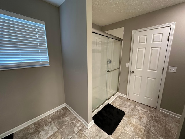 bathroom featuring a textured ceiling and an enclosed shower