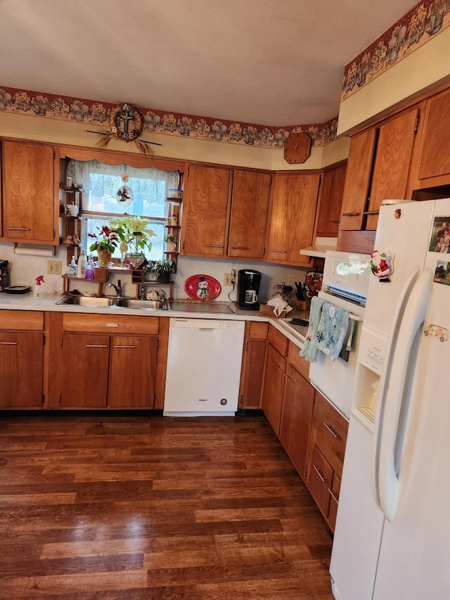 kitchen featuring range hood, sink, dark hardwood / wood-style floors, and white appliances