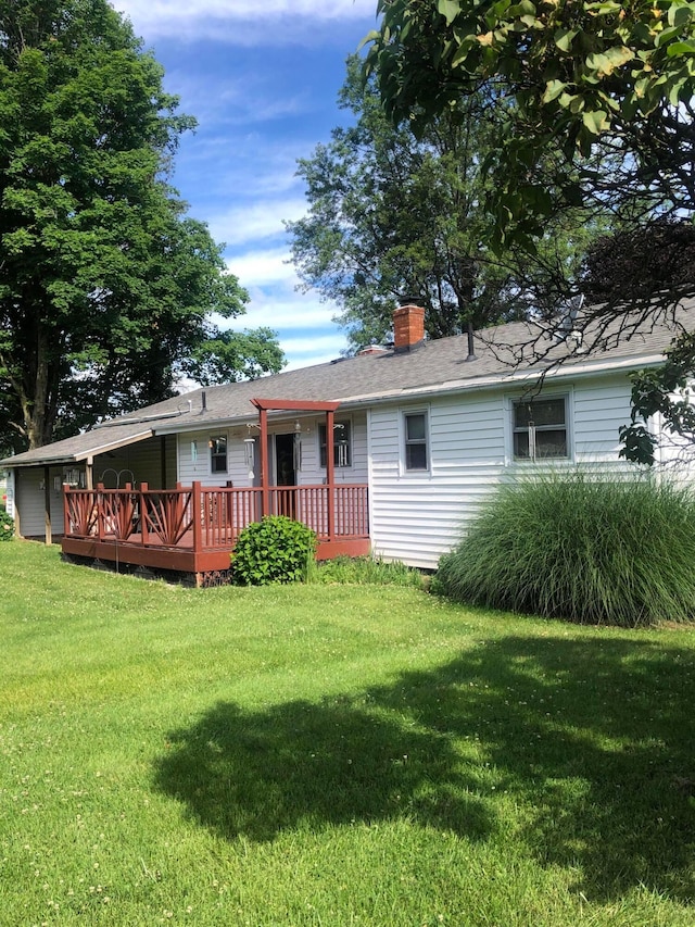 view of front of house with a wooden deck and a front lawn