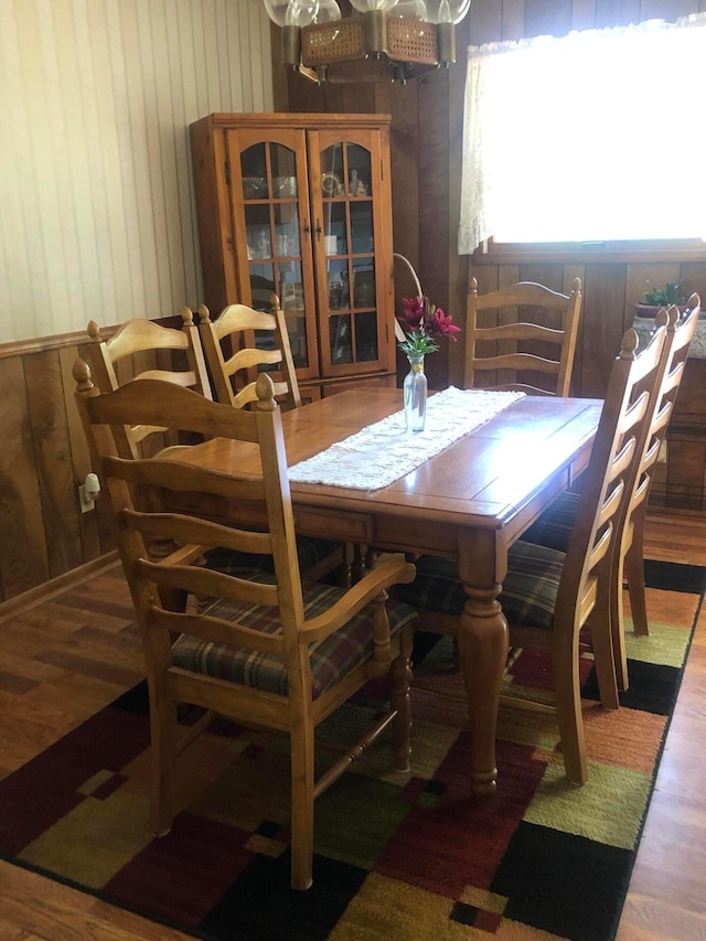 dining area featuring wooden walls and dark hardwood / wood-style flooring