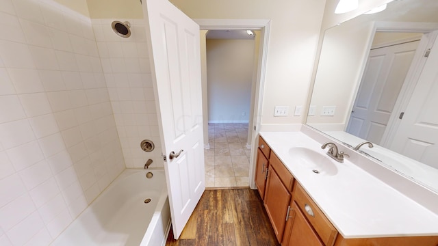 bathroom featuring hardwood / wood-style floors, vanity, and tiled shower / bath combo