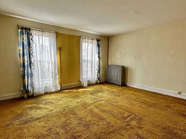 empty room with carpet flooring and radiator heating unit