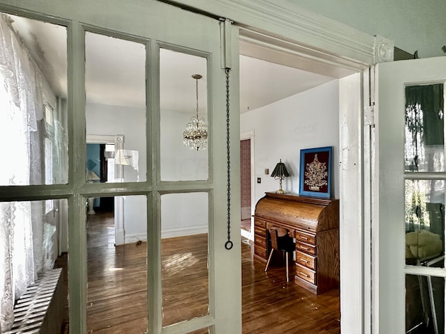 doorway to outside featuring a chandelier and dark hardwood / wood-style floors