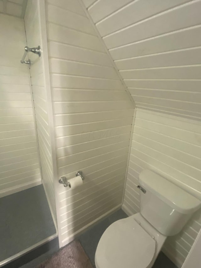 bathroom with wooden walls and toilet