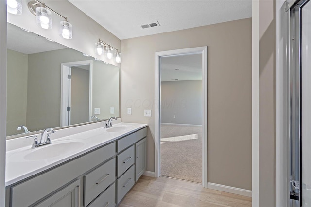 bathroom featuring a textured ceiling, vanity, and hardwood / wood-style flooring