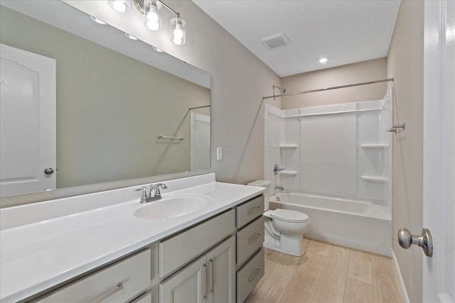 full bathroom with hardwood / wood-style flooring, vanity, toilet, and shower / bath combination