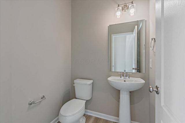 bathroom featuring hardwood / wood-style flooring, toilet, and sink