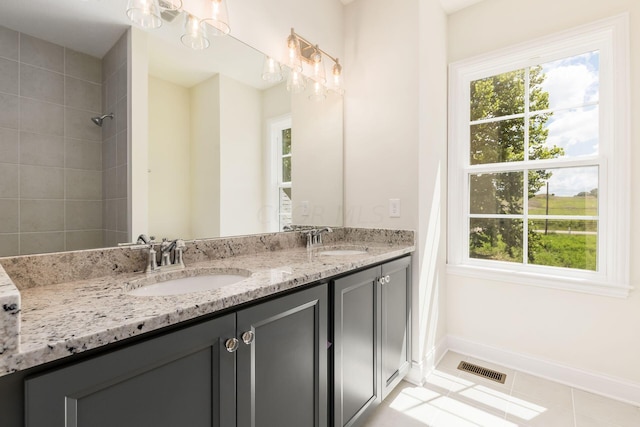 bathroom featuring tile patterned flooring, vanity, and tiled shower