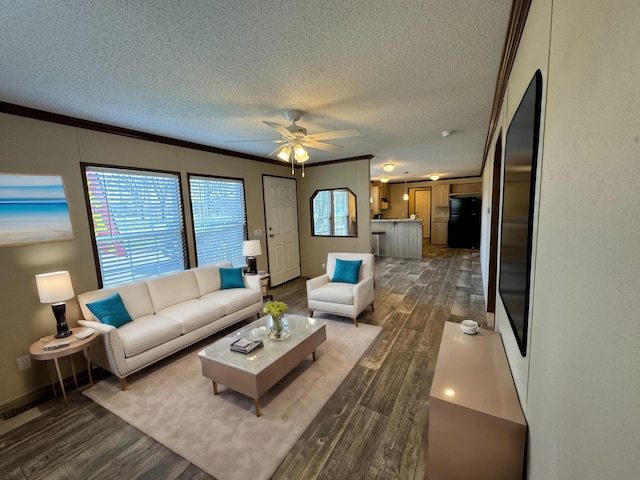 living room featuring crown molding, ceiling fan, dark wood-type flooring, and a textured ceiling