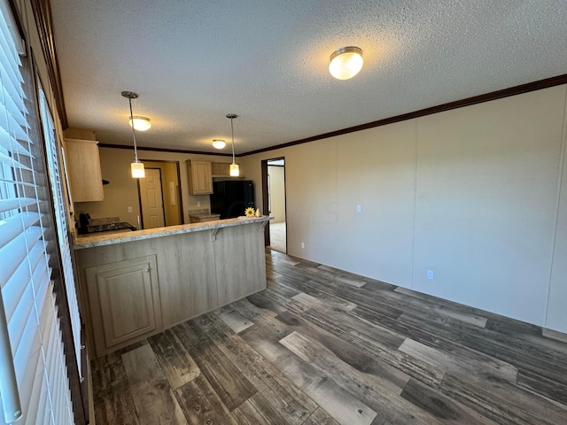 kitchen with kitchen peninsula, black fridge, crown molding, decorative light fixtures, and dark hardwood / wood-style floors