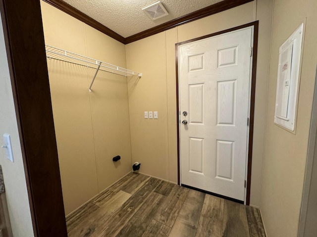 clothes washing area with a textured ceiling, dark hardwood / wood-style flooring, and ornamental molding