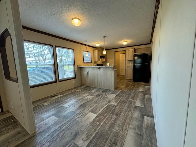 kitchen with dark wood-type flooring, black refrigerator, a textured ceiling, decorative light fixtures, and kitchen peninsula