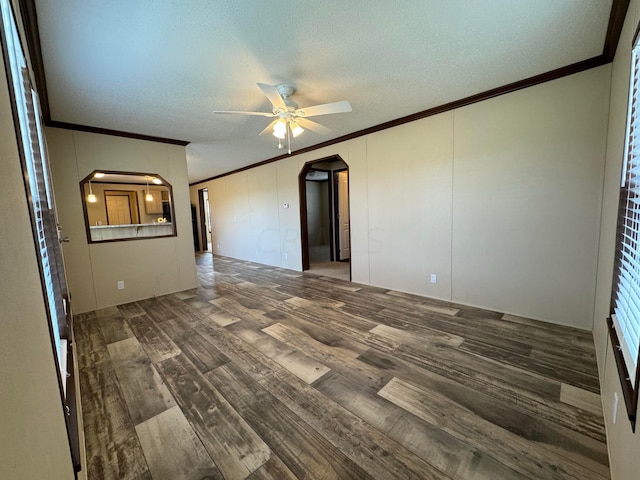 empty room featuring a textured ceiling, ceiling fan, dark hardwood / wood-style flooring, and crown molding