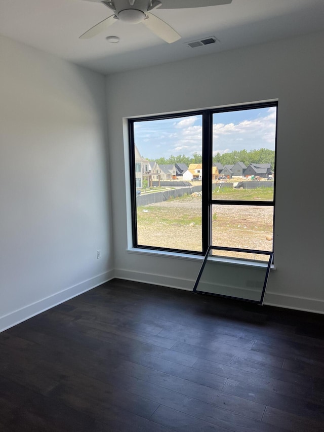 unfurnished room with ceiling fan and dark wood-type flooring