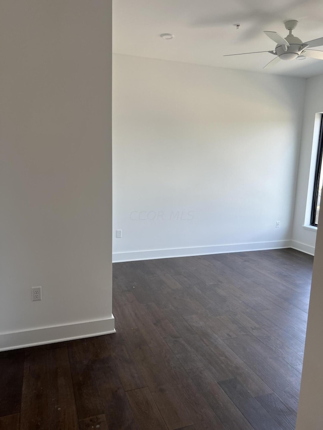 unfurnished room with dark hardwood / wood-style flooring and ceiling fan