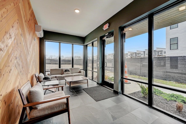 sunroom featuring a wall unit AC and plenty of natural light