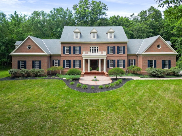 colonial-style house with a balcony and a front yard