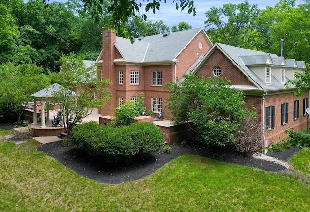 back of house featuring a lawn and a patio area