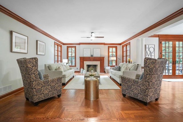 living room with french doors, ceiling fan, parquet flooring, ornamental molding, and decorative columns