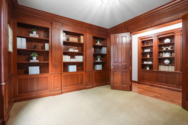 interior space featuring built in shelves, light hardwood / wood-style floors, and ornamental molding