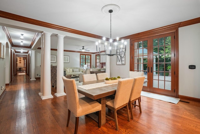 dining space featuring ornate columns, crown molding, hardwood / wood-style floors, and ceiling fan with notable chandelier