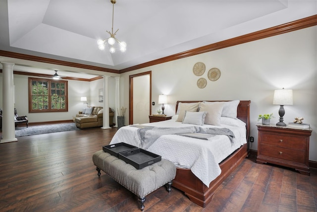 bedroom with ornate columns, ornamental molding, a tray ceiling, dark wood-type flooring, and a chandelier