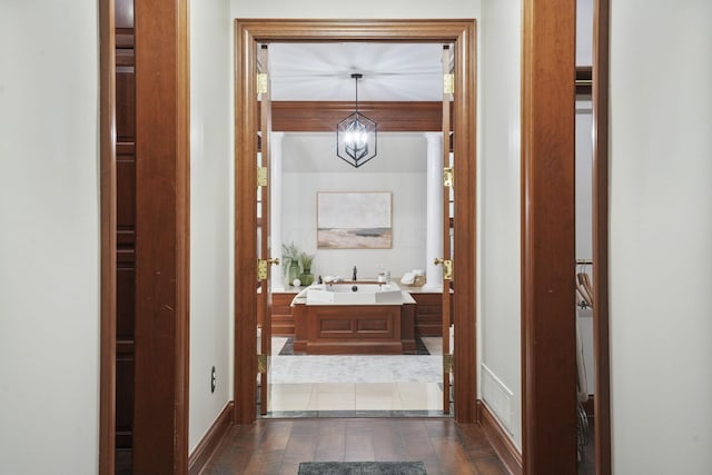 corridor featuring sink and a chandelier