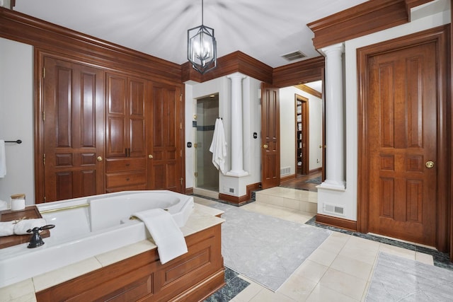 bathroom with tile patterned floors, ornate columns, a tub, and a chandelier