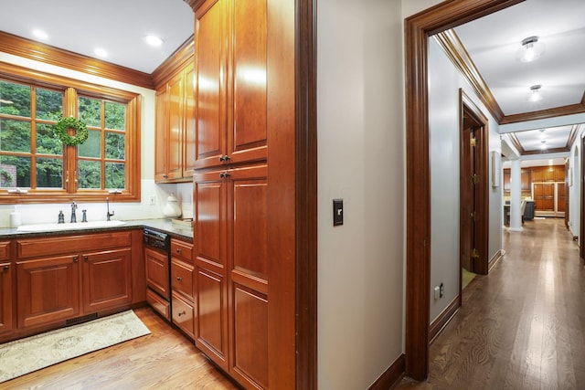 kitchen featuring black dishwasher, light hardwood / wood-style flooring, ornamental molding, and sink