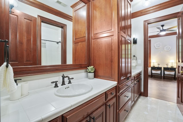 bathroom with vanity, crown molding, hardwood / wood-style flooring, ceiling fan, and walk in shower