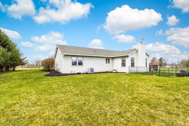 rear view of house with a lawn and central AC unit