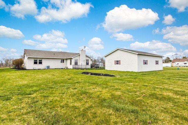 back of house featuring a yard and an outdoor structure