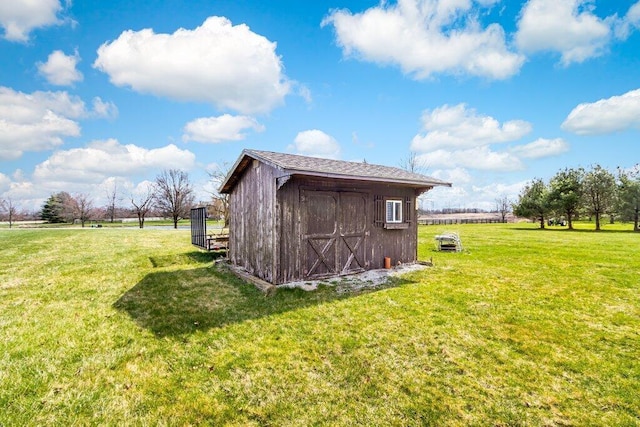 view of outbuilding with a yard and a rural view