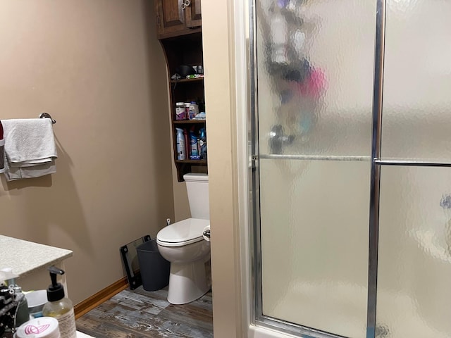 bathroom featuring hardwood / wood-style floors, vanity, toilet, and walk in shower