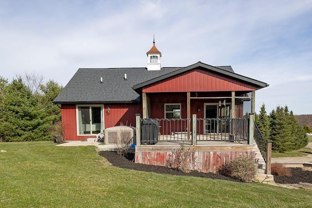 rear view of house with a porch and a yard