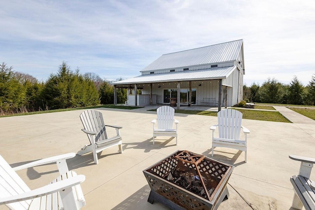 rear view of property featuring an outdoor fire pit and a patio area