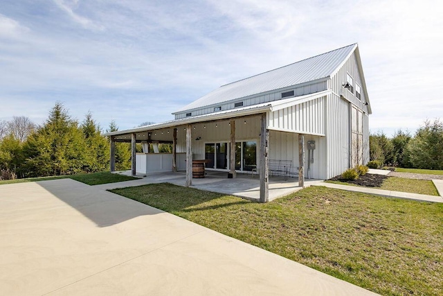 rear view of property with a lawn and a patio area