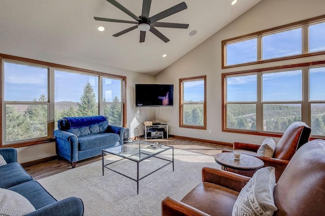 living room with hardwood / wood-style floors, plenty of natural light, ceiling fan, and high vaulted ceiling