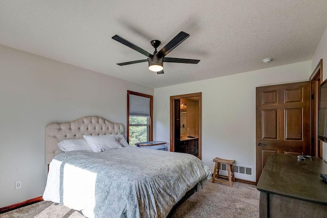 bedroom featuring ceiling fan, carpet, ensuite bathroom, and a textured ceiling