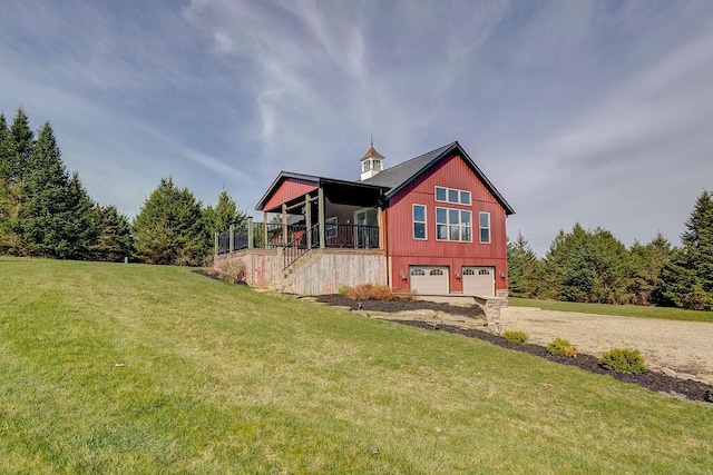 rear view of house with a garage and a lawn