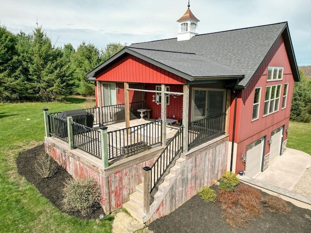 rear view of house featuring a garage and a yard