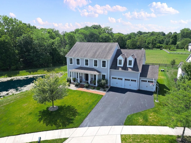 colonial-style house with a front yard, covered porch, and a garage