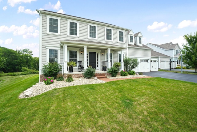 view of front facade with a front yard, a garage, and a porch