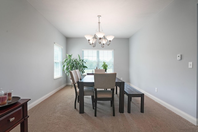 dining room featuring a chandelier and carpet floors