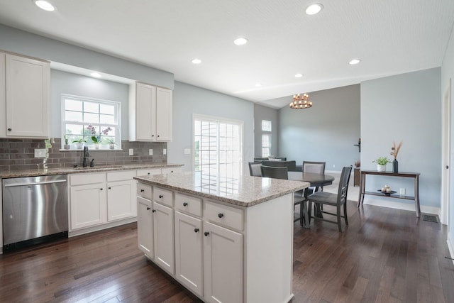 kitchen featuring tasteful backsplash, dishwasher, a center island, dark wood-type flooring, and white cabinets