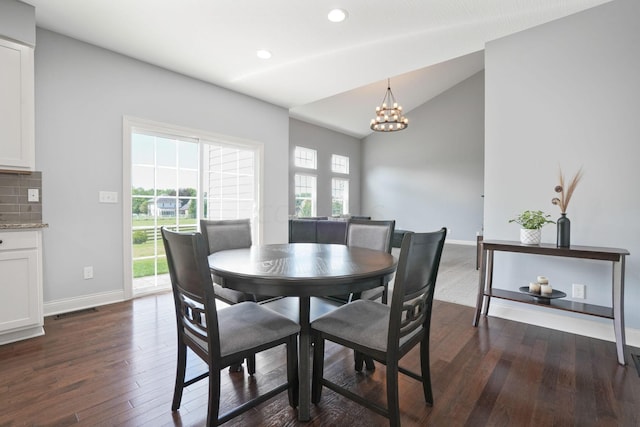 dining space featuring dark hardwood / wood-style floors, lofted ceiling, and a chandelier